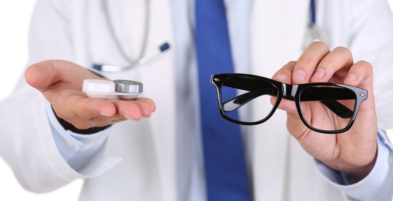 male doctor hands giving pair of black glasses